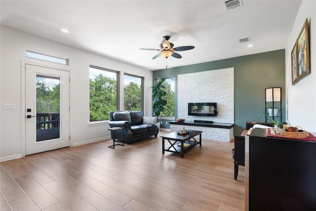 10636 Bramblecrest Dr, Austin, TX 78726 - living area with a ceiling fan, light wood-style flooring, a stone fireplace, and recessed lighting