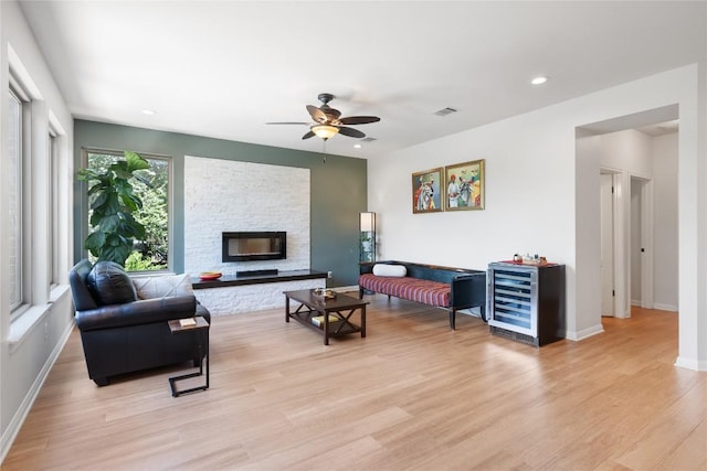 10636 Bramblecrest Dr, Austin, TX 78726 - living area featuring wine cooler, ceiling fan, light wood-style floors, recessed lighting, and a stone fireplace