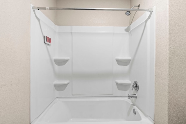 1698 Violet Ln, Kyle, TX 78640 - bathroom with a textured wall and washtub / shower combination