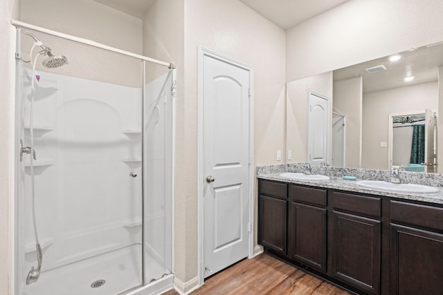 1698 Violet Ln, Kyle, TX 78640 - full bathroom featuring wood finished floors, a stall shower, and double vanity