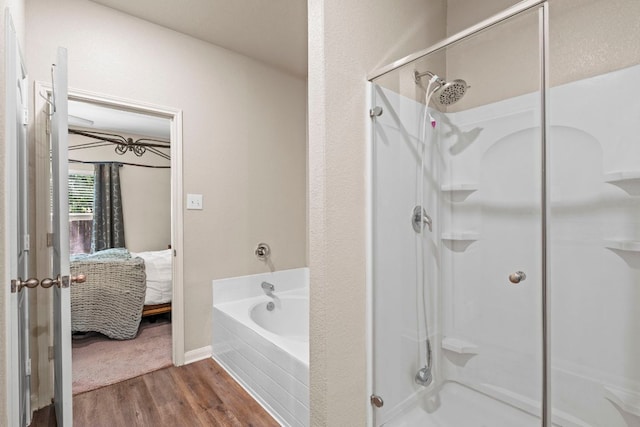 1698 Violet Ln, Kyle, TX 78640 - ensuite bathroom with a stall shower, a bath, and wood finished floors