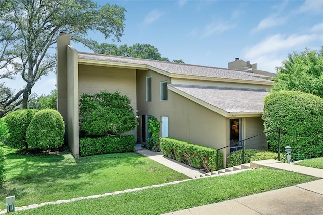 230 Lido St Unit I-2, Lakeway, TX 78734 - view of side of property featuring a shingled roof, a yard, stucco siding, and a chimney