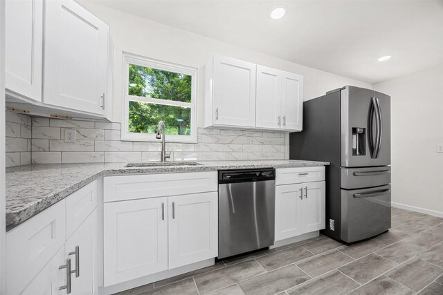 605 W Washington Ave, Copperas Cove, TX 76522 - kitchen featuring appliances with stainless steel finishes, white cabinetry, backsplash, light stone countertops, and recessed lighting