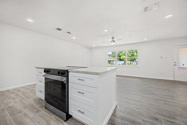 605 W Washington Ave, Copperas Cove, TX 76522 - kitchen with electric range oven, light wood-style floors, white cabinetry, recessed lighting, and ceiling fan