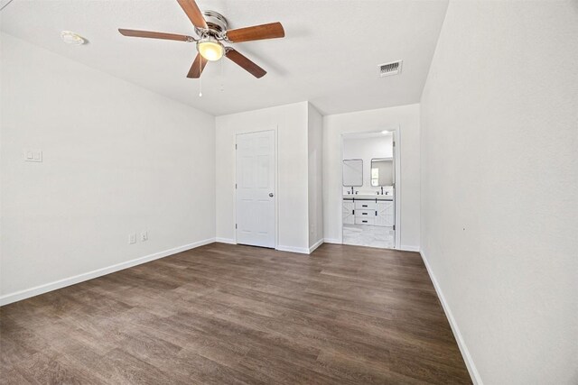 605 W Washington Ave, Copperas Cove, TX 76522 - unfurnished bedroom with dark wood-style floors, connected bathroom, and a ceiling fan
