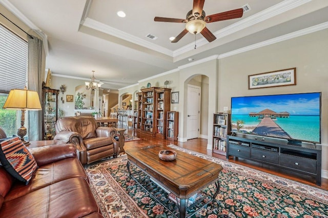 2010 American Dr Unit 2, Lago Vista, TX 78645 - living area with arched walkways, a raised ceiling, a ceiling fan, ornamental molding, and a chandelier