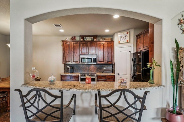 2010 American Dr Unit 2, Lago Vista, TX 78645 - kitchen with appliances with stainless steel finishes, arched walkways, a peninsula, a breakfast bar, and recessed lighting