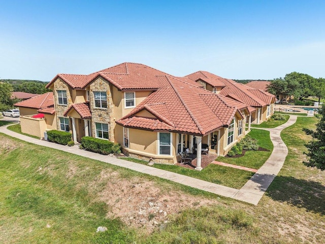 2010 American Dr Unit 2, Lago Vista, TX 78645 - townhome / multi-family property with stucco siding, a tiled roof, stone siding, and a front lawn