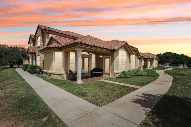 2010 American Dr Unit 2, Lago Vista, TX 78645 - view of property exterior featuring stucco siding, a ceiling fan, a yard, and a tiled roof