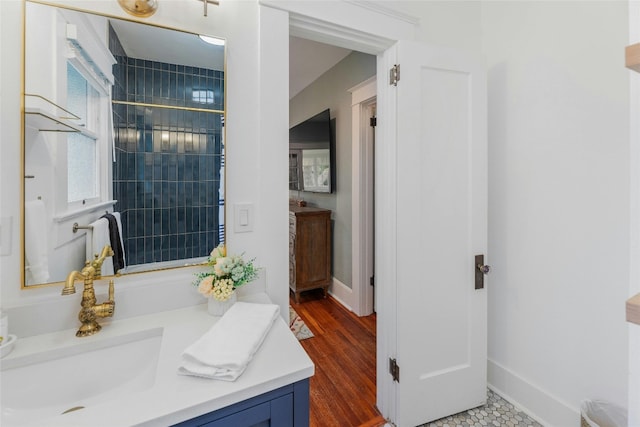 1502 Olive St, Georgetown, TX 78626 - bathroom featuring vanity, a tile shower, and wood finished floors