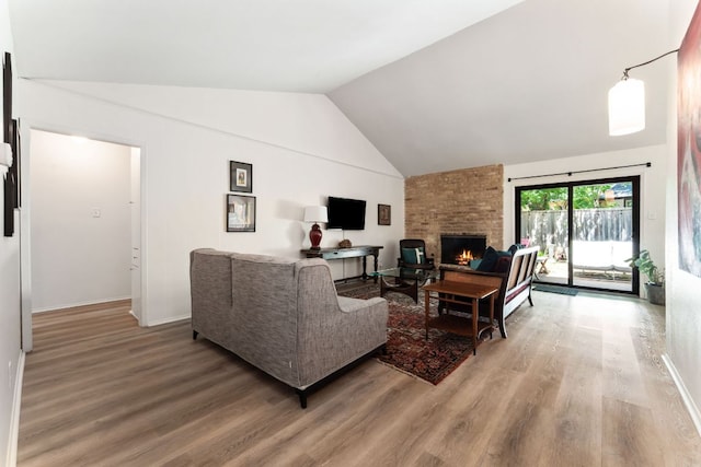 4903 Big Trail Cir, Austin, TX 78759 - living area featuring vaulted ceiling, a brick fireplace, and light wood finished floors