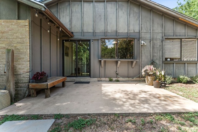 4903 Big Trail Cir, Austin, TX 78759 - rear view of house featuring board and batten siding, a patio area, and brick siding