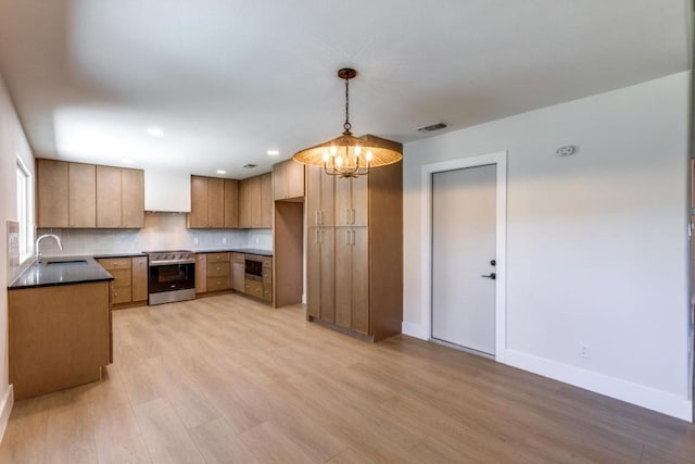 2515 Mcgregor Dr, Austin, TX 78745 - kitchen with appliances with stainless steel finishes, light wood finished floors, a chandelier, backsplash, and hanging light fixtures