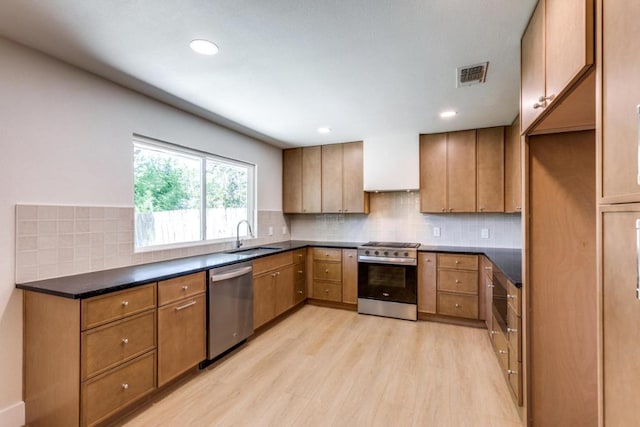 2515 Mcgregor Dr, Austin, TX 78745 - kitchen featuring stainless steel appliances, light wood-type flooring, dark countertops, backsplash, and brown cabinets