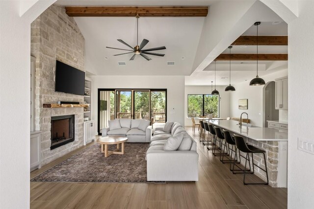 1129 Madrone Rd, Fischer, TX 78623 - living room with ceiling fan, a stone fireplace, wood finished floors, and arched walkways