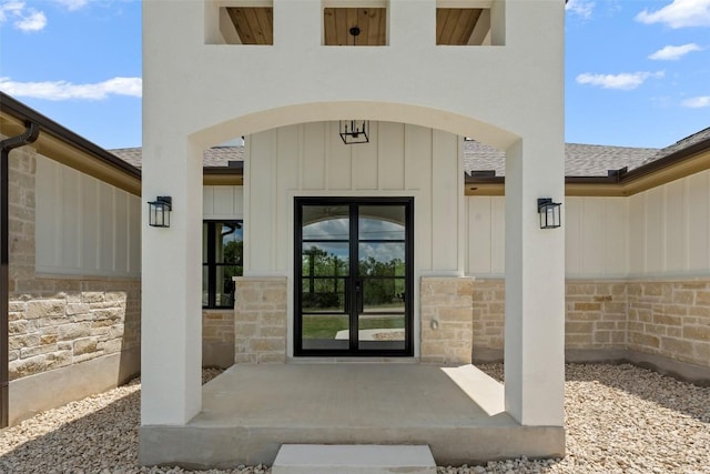 1129 Madrone Rd, Fischer, TX 78623 - property entrance featuring stone siding, french doors, board and batten siding, and roof with shingles