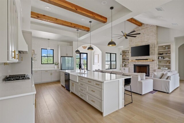 1129 Madrone Rd, Fischer, TX 78623 - kitchen featuring gas stovetop, a stone fireplace, light wood-type flooring, a breakfast bar area, and recessed lighting