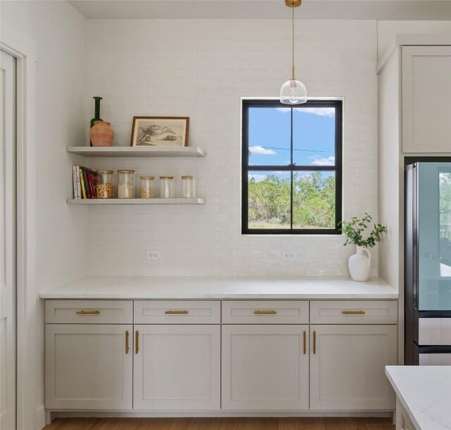 1129 Madrone Rd, Fischer, TX 78623 - bar featuring backsplash, hanging light fixtures, and stainless steel fridge