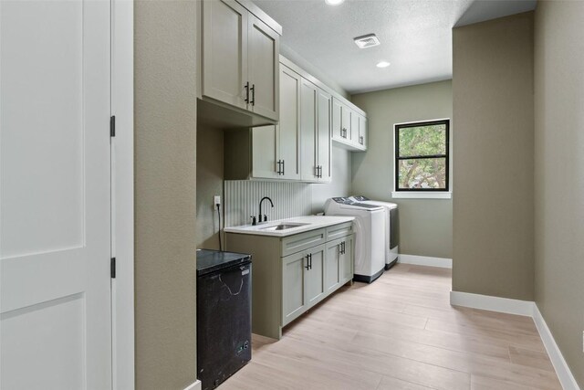 1129 Madrone Rd, Fischer, TX 78623 - laundry area featuring washer and dryer, cabinet space, light wood-type flooring, and recessed lighting