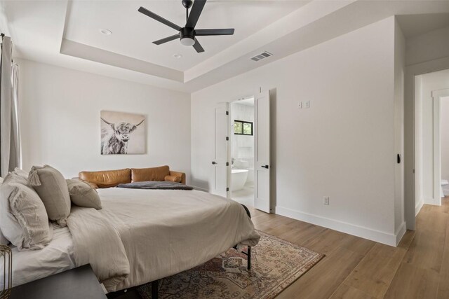 1129 Madrone Rd, Fischer, TX 78623 - bedroom with light wood-type flooring, a raised ceiling, ensuite bathroom, ceiling fan, and recessed lighting