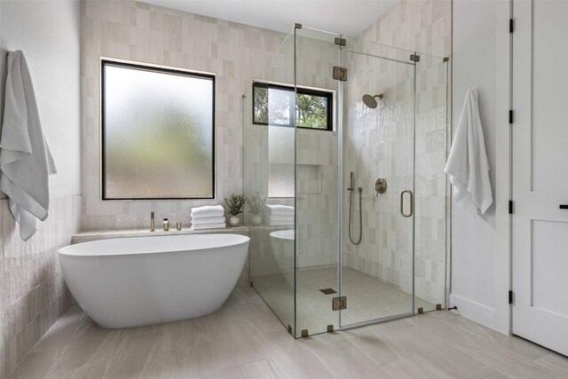 1129 Madrone Rd, Fischer, TX 78623 - full bathroom featuring a freestanding tub, a shower stall, and tile walls
