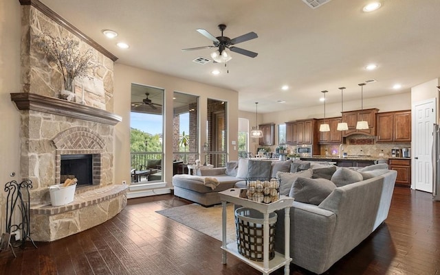 2308 First Vw, Leander, TX 78641 - living area featuring a ceiling fan, dark wood-style floors, a stone fireplace, and recessed lighting