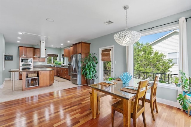 18917 Peckham Dr, Point Venture, TX 78645 - dining area with light wood finished floors, a chandelier, recessed lighting, and beverage cooler