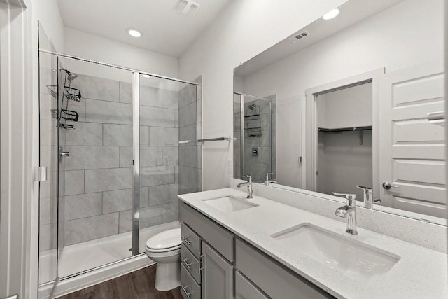 7707 Jackson Graham Dr, Austin, TX 78724 - bathroom with a stall shower, double vanity, wood finished floors, recessed lighting, and a spacious closet