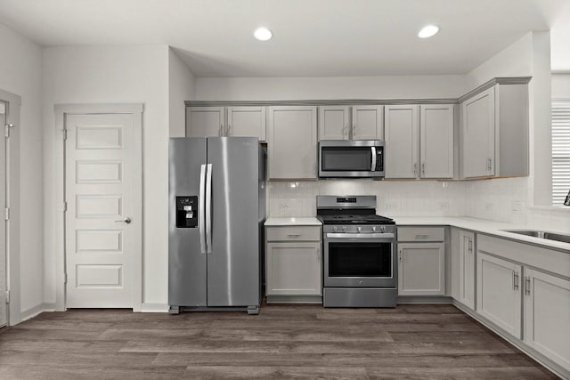7707 Jackson Graham Dr, Austin, TX 78724 - kitchen featuring stainless steel appliances, gray cabinets, backsplash, light countertops, and recessed lighting