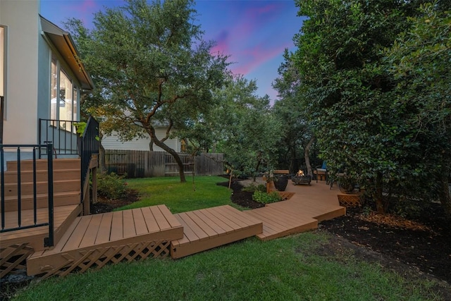 202 Hazy Hills Loop, Dripping Springs, TX 78620 - yard at dusk featuring a fenced backyard and a deck