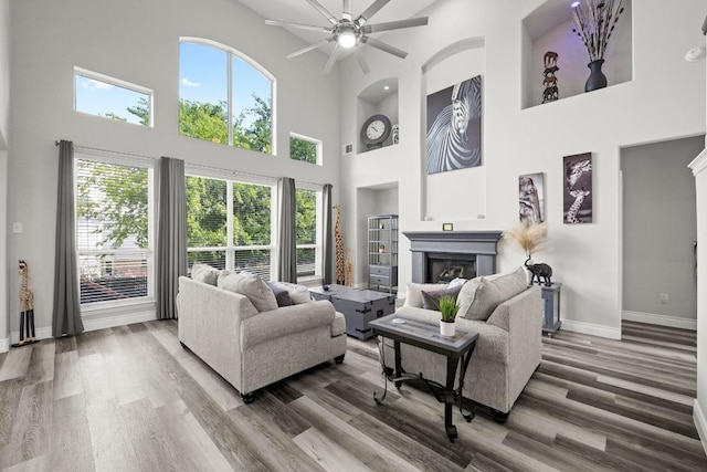 1901 Phantom Horse, Leander, TX 78641 - living area featuring a high ceiling, a glass covered fireplace, a ceiling fan, and wood finished floors