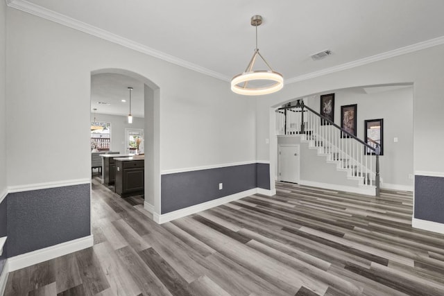 1901 Phantom Horse, Leander, TX 78641 - unfurnished dining area featuring arched walkways, wood finished floors, crown molding, and stairs
