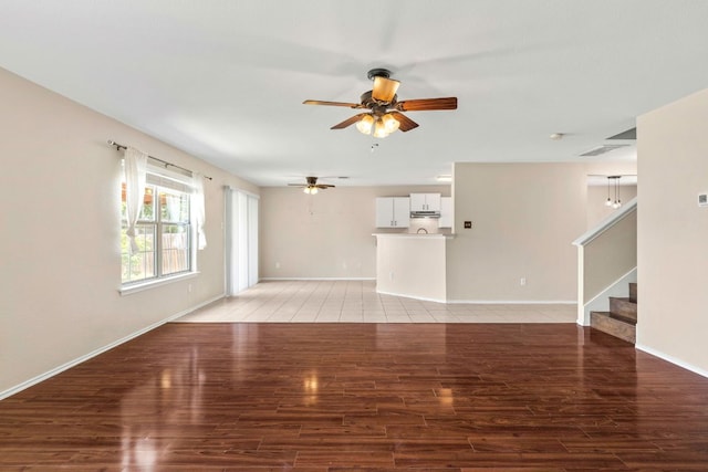 201 Windridge Dr N, Lockhart, TX 78644 - unfurnished living room featuring a ceiling fan, stairway, and light wood finished floors