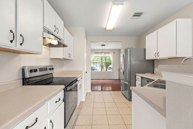 201 Windridge Dr N, Lockhart, TX 78644 - kitchen with appliances with stainless steel finishes, under cabinet range hood, light countertops, and light tile patterned flooring