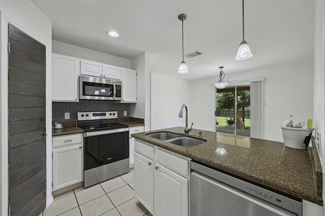 2309 New Hope Spur, Cedar Park, TX 78613 - kitchen with appliances with stainless steel finishes, white cabinetry, and dark stone countertops