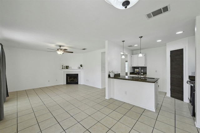 2309 New Hope Spur, Cedar Park, TX 78613 - kitchen with dark countertops, light tile patterned floors, ceiling fan, white cabinets, and recessed lighting
