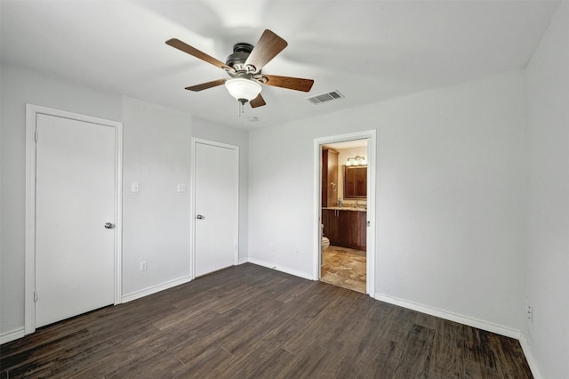 2309 New Hope Spur, Cedar Park, TX 78613 - unfurnished bedroom featuring dark wood-style floors, ceiling fan, and ensuite bathroom