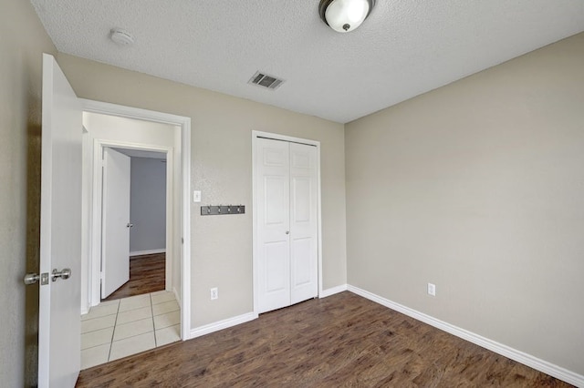 2309 New Hope Spur, Cedar Park, TX 78613 - unfurnished bedroom featuring a closet, a textured ceiling, and wood finished floors