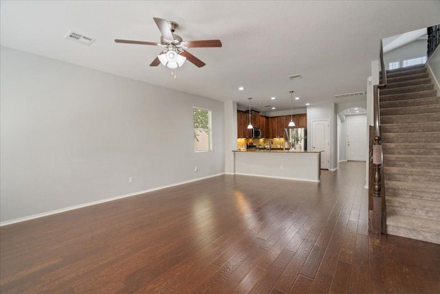 15 Stone Terrace Dr, Austin, TX 78734 - unfurnished living room with ceiling fan, stairway, dark wood-style flooring, recessed lighting, and arched walkways