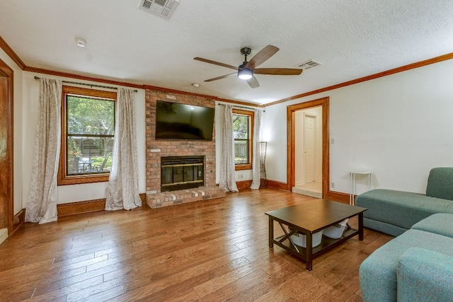 506 Applewood Dr, Pflugerville, TX 78660 - living area featuring plenty of natural light, a ceiling fan, hardwood / wood-style flooring, a fireplace, and crown molding