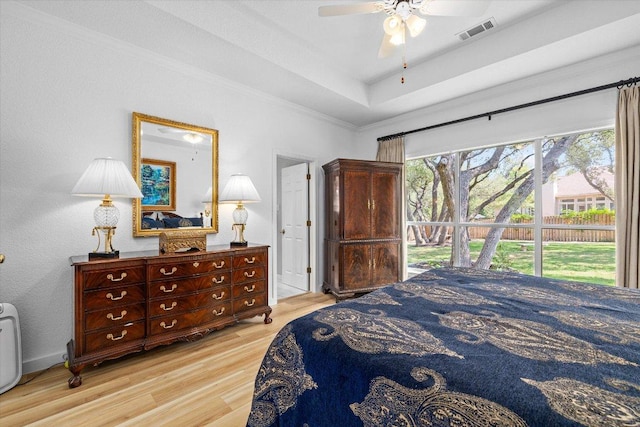 103 El Norte Ct, Lakeway, TX 78734 - bedroom featuring wood finished floors, a tray ceiling, ornamental molding, and ceiling fan