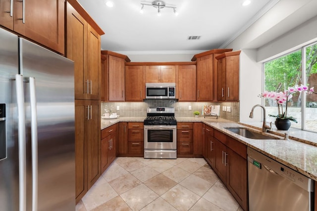 10919 Sierra Oaks, Austin, TX 78759 - kitchen featuring appliances with stainless steel finishes, crown molding, brown cabinetry, backsplash, and light stone countertops