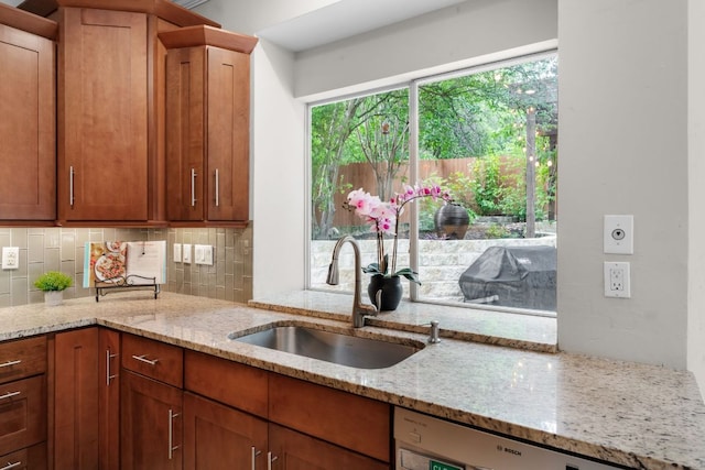 10919 Sierra Oaks, Austin, TX 78759 - kitchen with dishwashing machine, tasteful backsplash, light stone countertops, and brown cabinetry