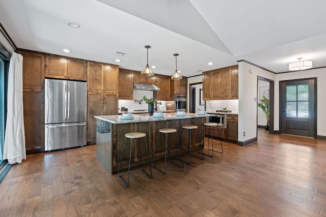 2717 Jorwoods Dr, Austin, TX 78745 - kitchen with appliances with stainless steel finishes, backsplash, a center island, light stone countertops, and lofted ceiling