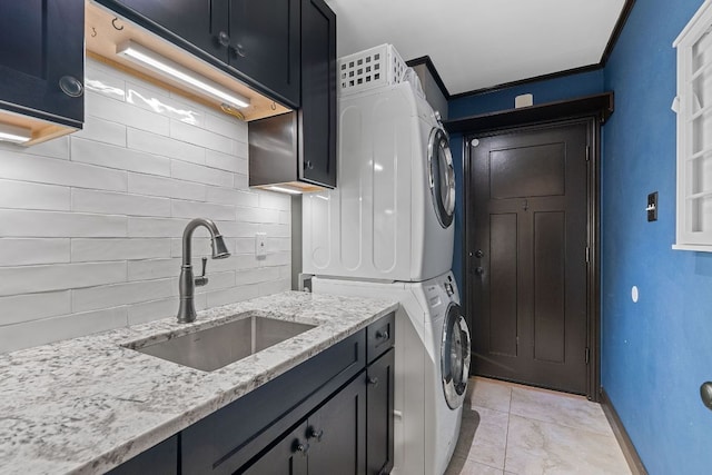 2717 Jorwoods Dr, Austin, TX 78745 - laundry area with stacked washer and clothes dryer, cabinet space, ornamental molding, and light tile patterned floors