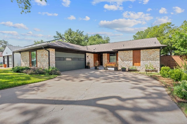 2717 Jorwoods Dr, Austin, TX 78745 - view of front of house featuring stone siding, an attached garage, and concrete driveway
