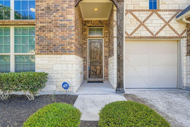 6716 Calabria Dr, Round Rock, TX 78665 - doorway to property featuring brick siding, an attached garage, and stone siding