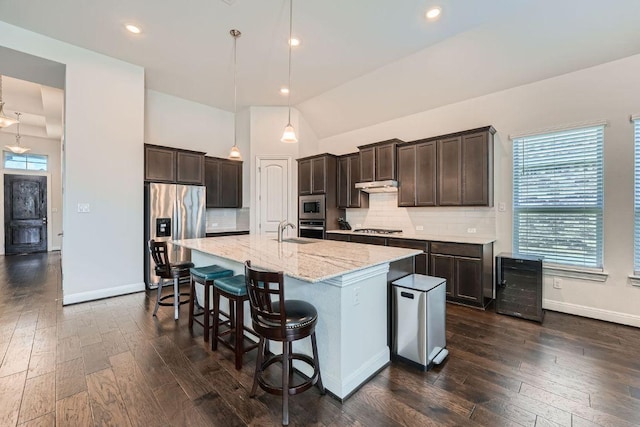 6716 Calabria Dr, Round Rock, TX 78665 - kitchen featuring appliances with stainless steel finishes, beverage cooler, dark brown cabinetry, healthy amount of natural light, and vaulted ceiling