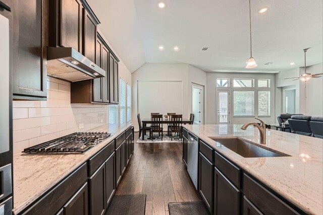 6716 Calabria Dr, Round Rock, TX 78665 - kitchen featuring appliances with stainless steel finishes, range hood, dark wood-style floors, recessed lighting, and light stone counters