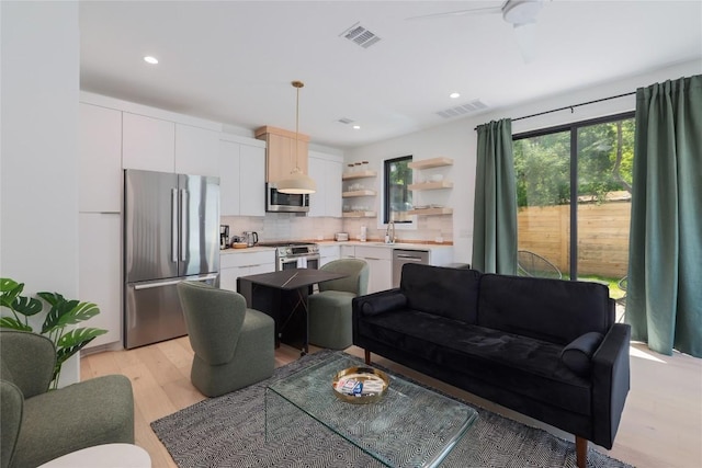 87 Chalmers Ave, Austin, TX 78702 - living room featuring light wood-style flooring, ceiling fan, and recessed lighting